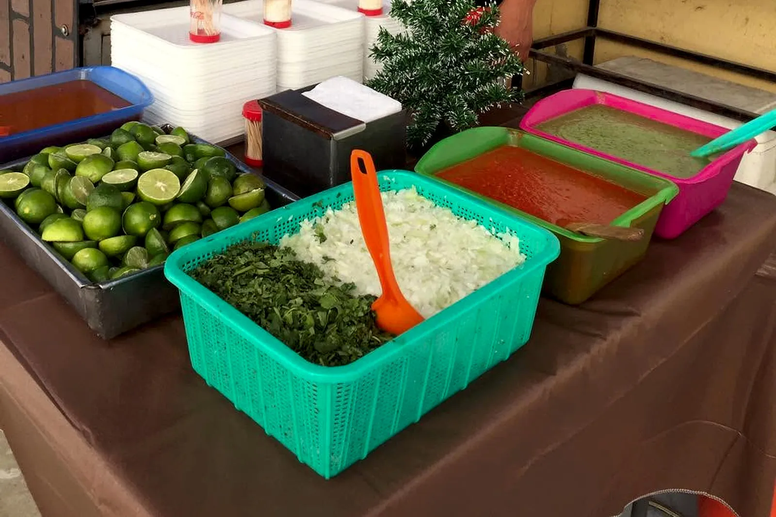 Mesa de taquiza montada con salsas, limones, cebolla y cilantro