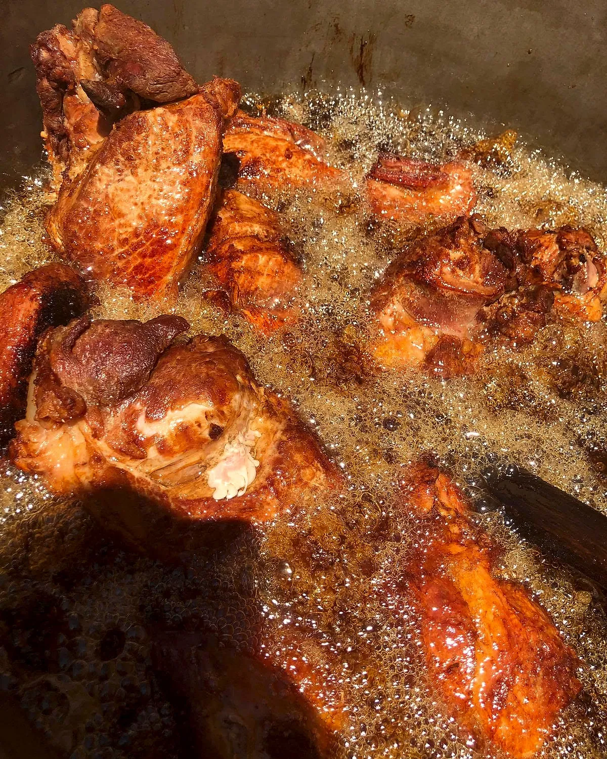 Carne de cerdo sellándose en manteca hirviendo dentro del cazo de Carnitas Alfaro